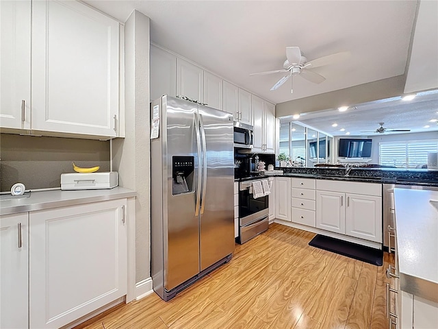 120 1st St E Unit 104, Saint Petersburg, FL 33715 - kitchen featuring stainless steel appliances, a ceiling fan, light wood-type flooring, and white cabinetry