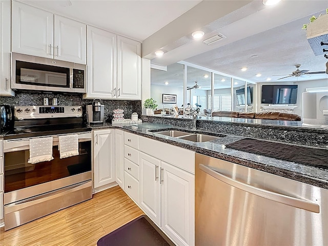 120 1st St E Unit 104, Saint Petersburg, FL 33715 - kitchen featuring stainless steel appliances, ceiling fan, white cabinetry, and recessed lighting