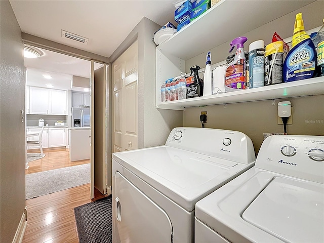 120 1st St E Unit 104, Saint Petersburg, FL 33715 - washroom with independent washer and dryer and light wood-type flooring