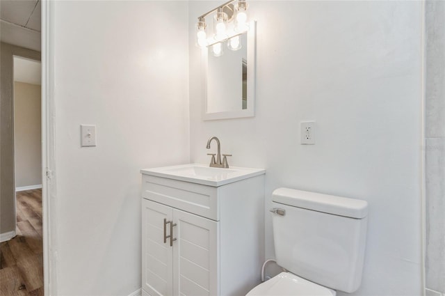 1727 Bonita Ave, Orlando, FL 32805 - bathroom featuring wood finished floors, toilet, vanity, and baseboards