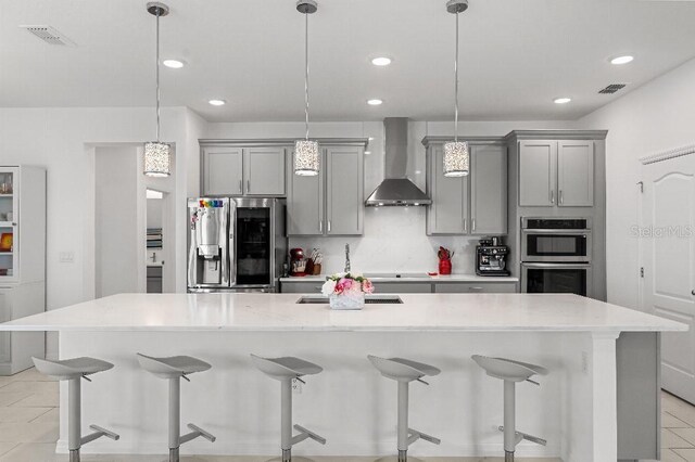 921 Fieldstone Way, Haines City, FL 33844 - kitchen featuring wall chimney exhaust hood, stainless steel appliances, gray cabinets, a large island with sink, and recessed lighting