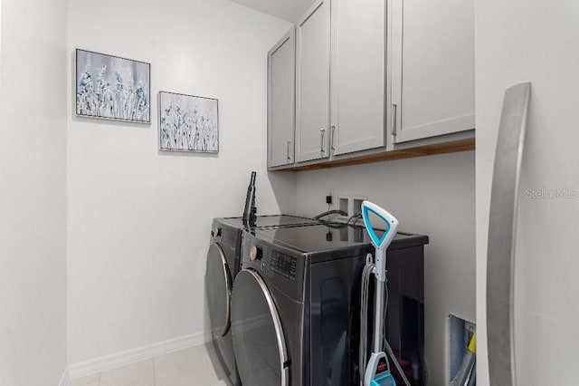 921 Fieldstone Way, Haines City, FL 33844 - washroom featuring washing machine and dryer, cabinet space, baseboards, and light tile patterned flooring