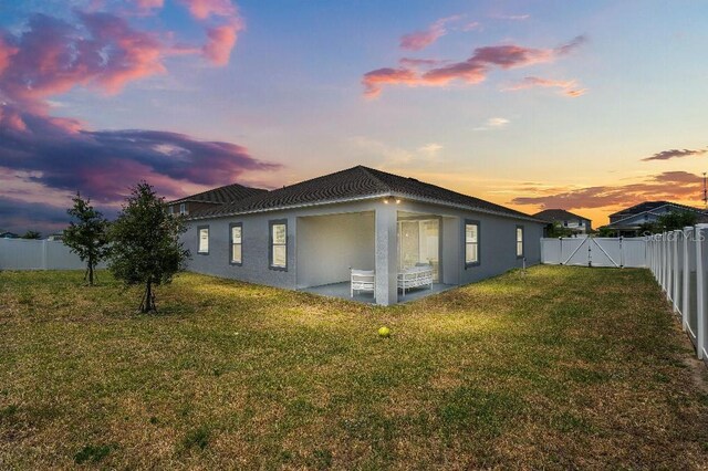 921 Fieldstone Way, Haines City, FL 33844 - view of property exterior featuring stucco siding, a patio, and a gate