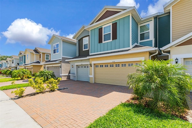 4316 Sailplane Ct, Wesley Chapel, FL 33545 - townhome / multi-family property with an attached garage, decorative driveway, board and batten siding, and stucco siding