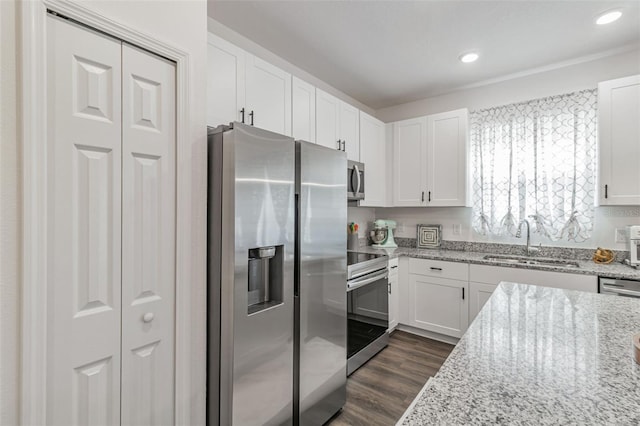 4316 Sailplane Ct, Wesley Chapel, FL 33545 - kitchen featuring stainless steel appliances, a sink, white cabinets, dark wood-style flooring, and light stone countertops