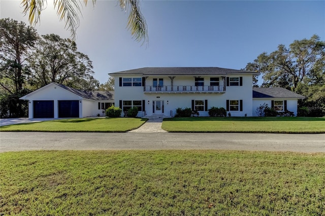 1089 Virginia St, Dunedin, FL 34698 - view of front of house featuring a balcony, driveway, a front yard, stucco siding, and a garage