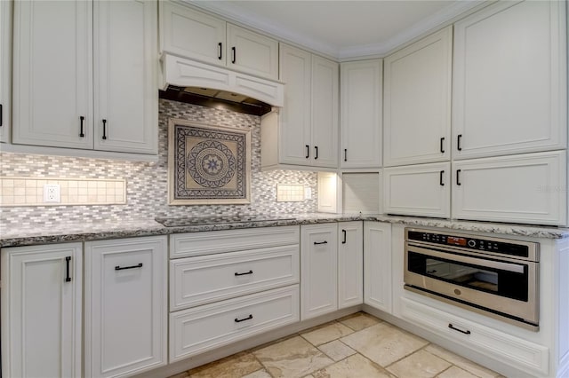1089 Virginia St, Dunedin, FL 34698 - kitchen with stainless steel oven, custom range hood, decorative backsplash, and light stone countertops