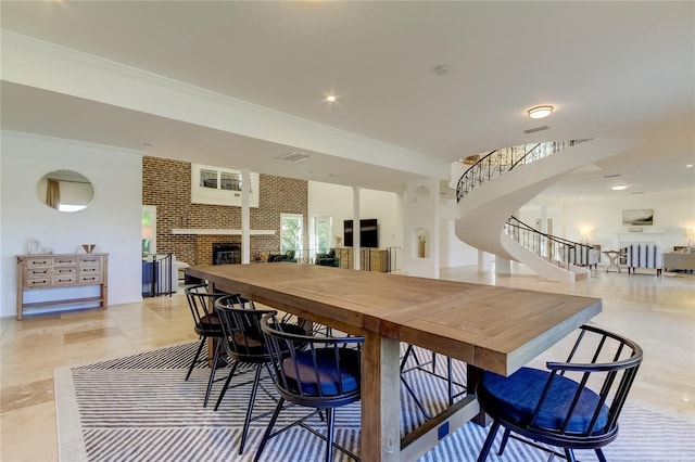 1089 Virginia St, Dunedin, FL 34698 - dining area with stairway, a fireplace, crown molding, and light tile patterned floors