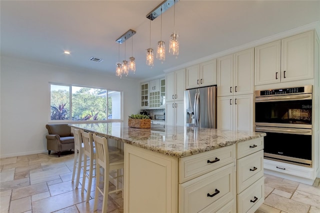 1089 Virginia St, Dunedin, FL 34698 - kitchen featuring stainless steel appliances, a chandelier, light stone counters, stone tile floors, and recessed lighting