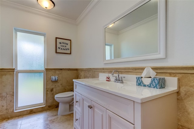 1089 Virginia St, Dunedin, FL 34698 - bathroom featuring tile walls, vanity, toilet, ornamental molding, and a wainscoted wall