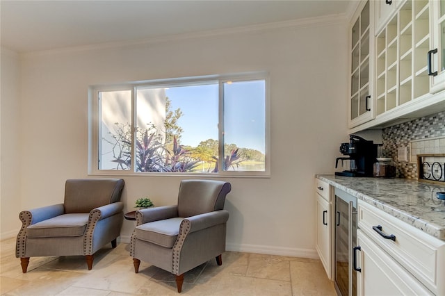 1089 Virginia St, Dunedin, FL 34698 - sitting room featuring beverage cooler, crown molding, baseboards, and a bar