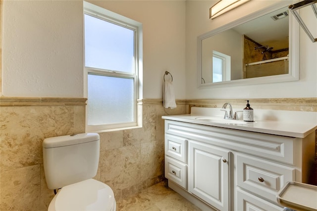 1089 Virginia St, Dunedin, FL 34698 - bathroom featuring tile walls, a wainscoted wall, vanity, toilet, and a shower