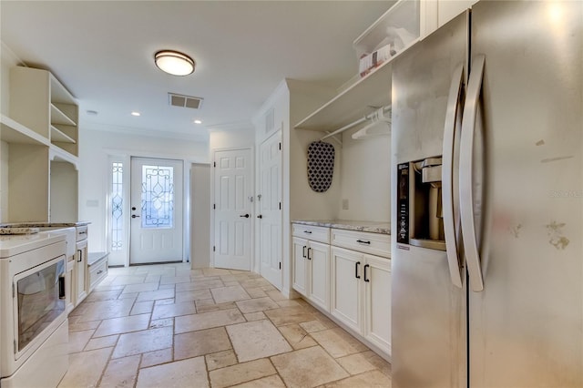 1089 Virginia St, Dunedin, FL 34698 - kitchen with stainless steel refrigerator with ice dispenser, open shelves, crown molding, stone tile flooring, and white cabinetry