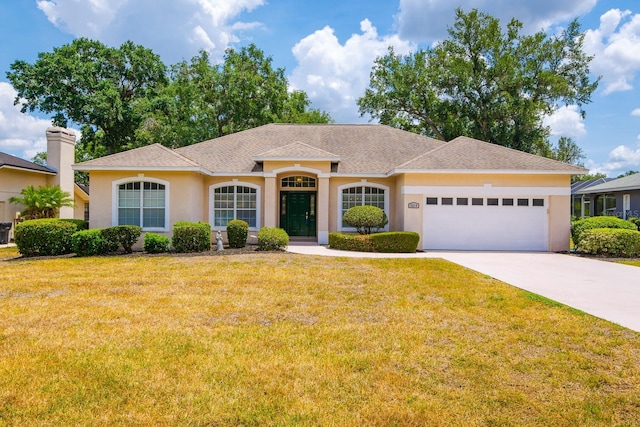 2214 Deerbrook Dr, Lakeland, FL 33811 - ranch-style home featuring a garage, stucco siding, concrete driveway, a front yard, and a shingled roof