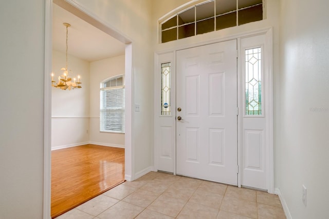 2214 Deerbrook Dr, Lakeland, FL 33811 - foyer with a chandelier, light tile patterned flooring, and baseboards