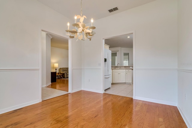 2214 Deerbrook Dr, Lakeland, FL 33811 - unfurnished dining area with a chandelier, light wood-type flooring, and a sink