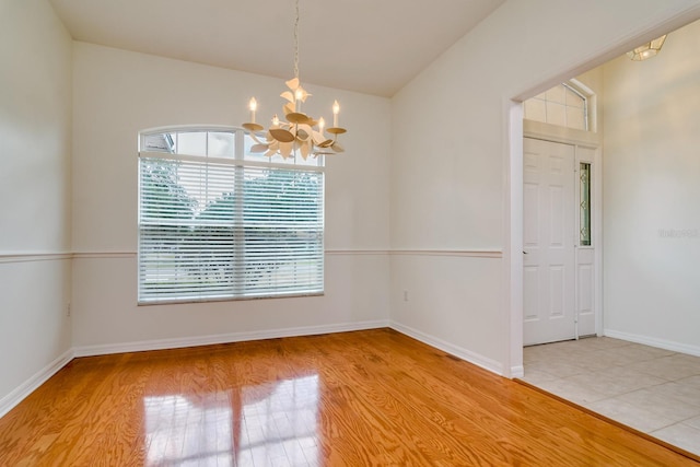 2214 Deerbrook Dr, Lakeland, FL 33811 - spare room with a chandelier, wood finished floors, vaulted ceiling, and baseboards