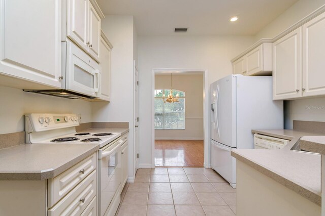 2214 Deerbrook Dr, Lakeland, FL 33811 - kitchen with white appliances, light tile patterned flooring, a chandelier, light countertops, and white cabinets