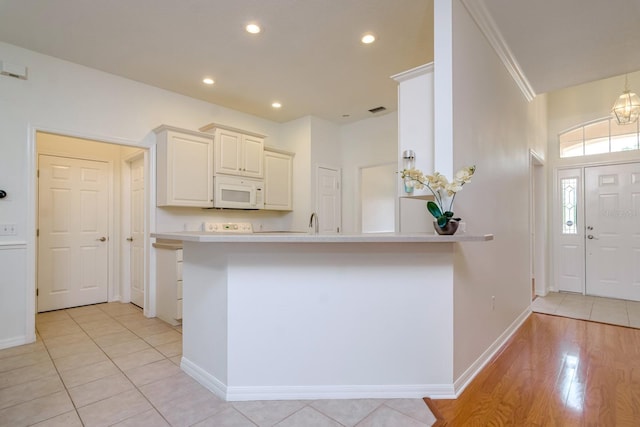 2214 Deerbrook Dr, Lakeland, FL 33811 - kitchen with white microwave, light countertops, baseboards, recessed lighting, and a peninsula