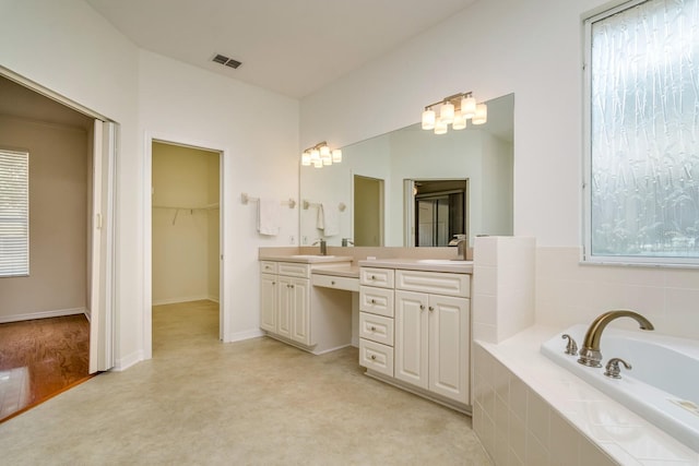 2214 Deerbrook Dr, Lakeland, FL 33811 - bathroom featuring a garden tub, a walk in closet, and vanity