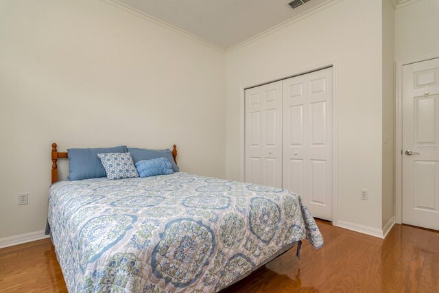 2214 Deerbrook Dr, Lakeland, FL 33811 - bedroom with wood finished floors, ornamental molding, baseboards, and a closet