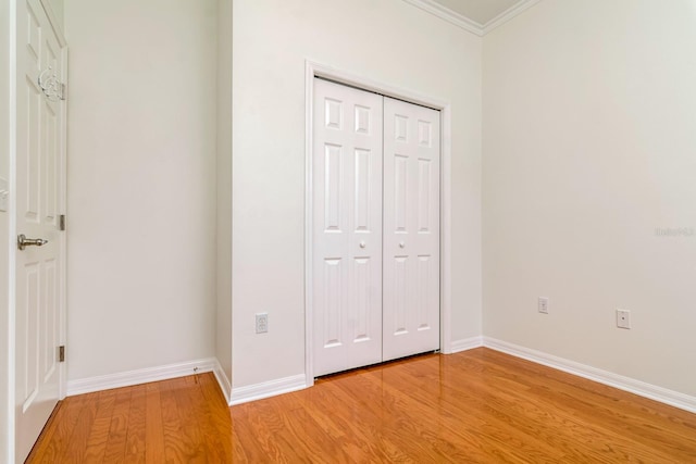 2214 Deerbrook Dr, Lakeland, FL 33811 - unfurnished bedroom with light wood finished floors, ornamental molding, a closet, and baseboards
