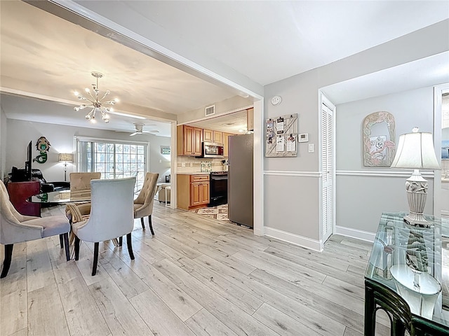 dining area featuring a chandelier, light wood-style floors, baseboards, and a ceiling fan