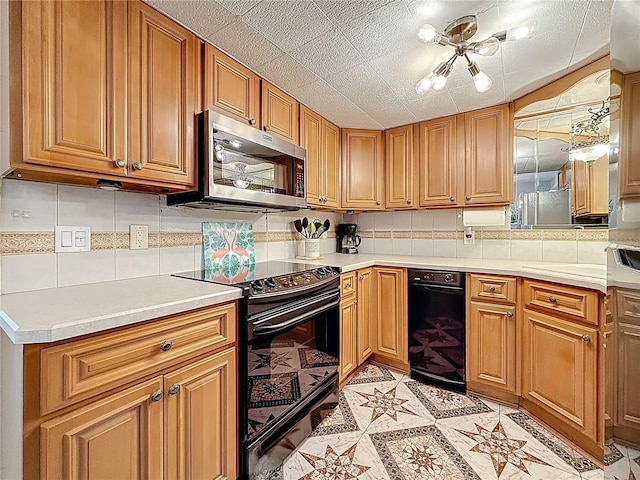 kitchen featuring stainless steel microwave, black electric range, tasteful backsplash, light countertops, and brown cabinetry
