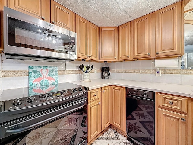 kitchen with stainless steel microwave, electric range, light countertops, and decorative backsplash