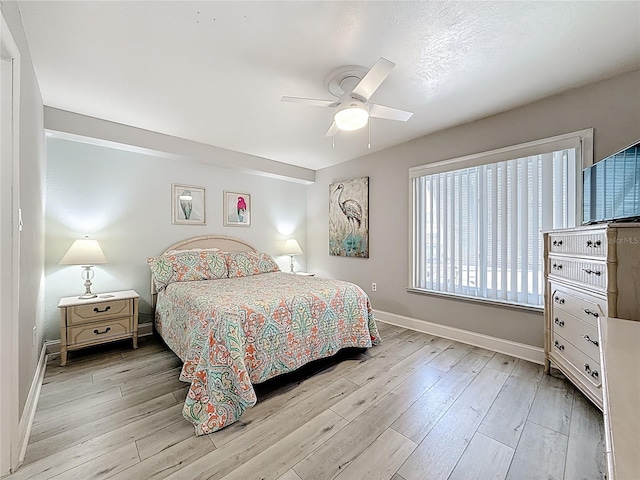 bedroom with baseboards, light wood-style flooring, and a ceiling fan