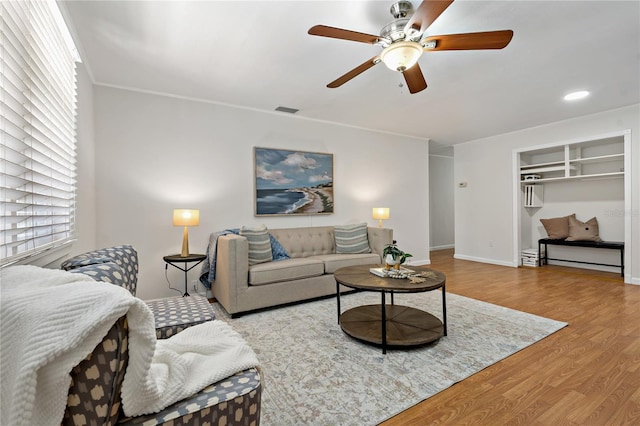 39542 Friends Ave, Zephyrhills, FL 33540 - living area featuring wood finished floors, a ceiling fan, and ornamental molding