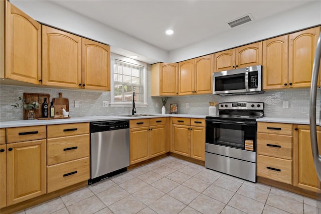 39542 Friends Ave, Zephyrhills, FL 33540 - kitchen featuring stainless steel appliances, light tile patterned flooring, light countertops, and recessed lighting