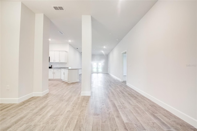 unfurnished living room featuring light wood-type flooring and baseboards