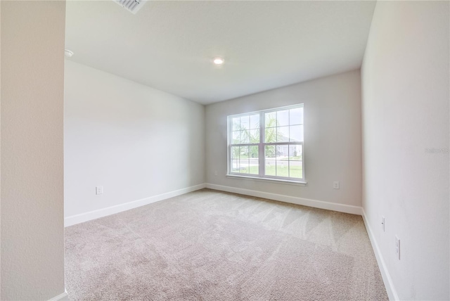 unfurnished room with light carpet and baseboards