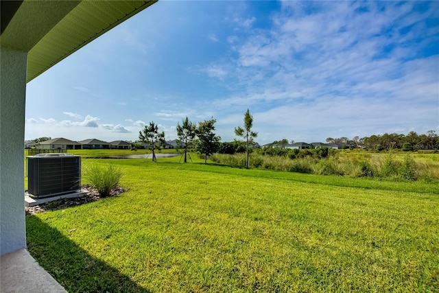 view of grassy yard with cooling unit and a residential view
