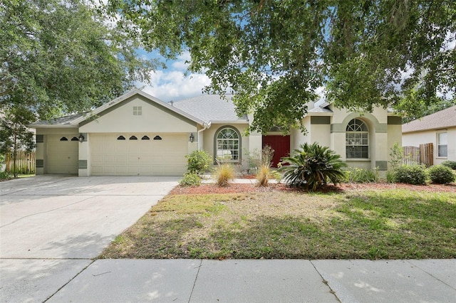 single story home featuring an attached garage, stucco siding, driveway, and fence