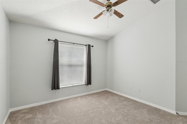 carpeted spare room with ceiling fan, baseboards, and a textured ceiling