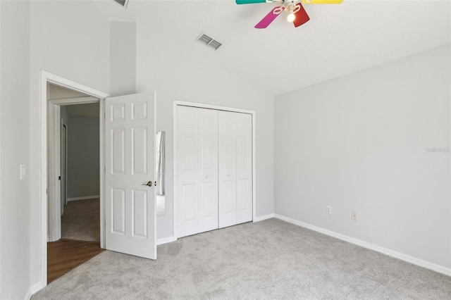unfurnished bedroom with carpet flooring, vaulted ceiling, baseboards, a closet, and ceiling fan