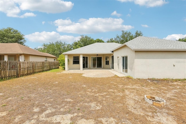 rear view of house with a ceiling fan, fence, stucco siding, and a patio