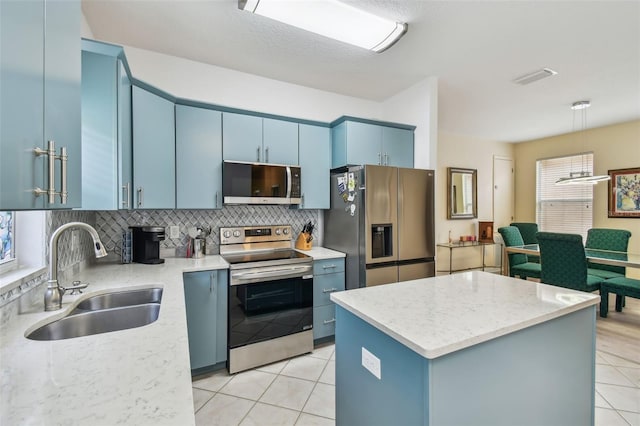 3762 Darston St, Palm Harbor, FL 34685 - kitchen featuring appliances with stainless steel finishes, blue cabinetry, a sink, light tile patterned flooring, and decorative backsplash