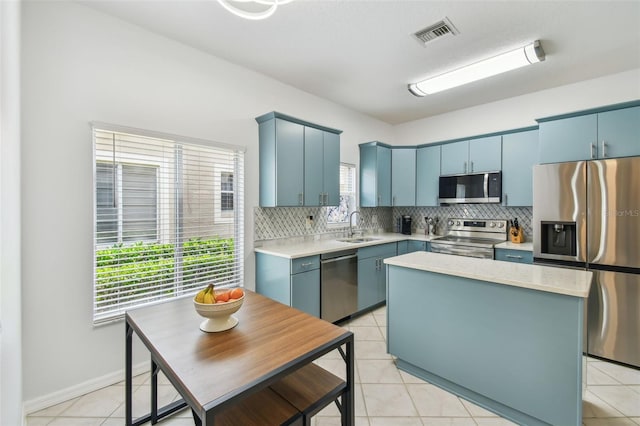 3762 Darston St, Palm Harbor, FL 34685 - kitchen with appliances with stainless steel finishes, blue cabinetry, a sink, light countertops, and backsplash