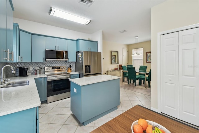 3762 Darston St, Palm Harbor, FL 34685 - kitchen with stainless steel appliances, blue cabinets, a sink, a kitchen island, and backsplash