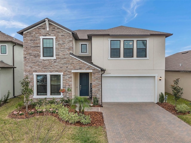 22294 Storybook Cabin Way, Land O Lakes, FL 34637 - view of front of home with stone siding, stucco siding, decorative driveway, and an attached garage