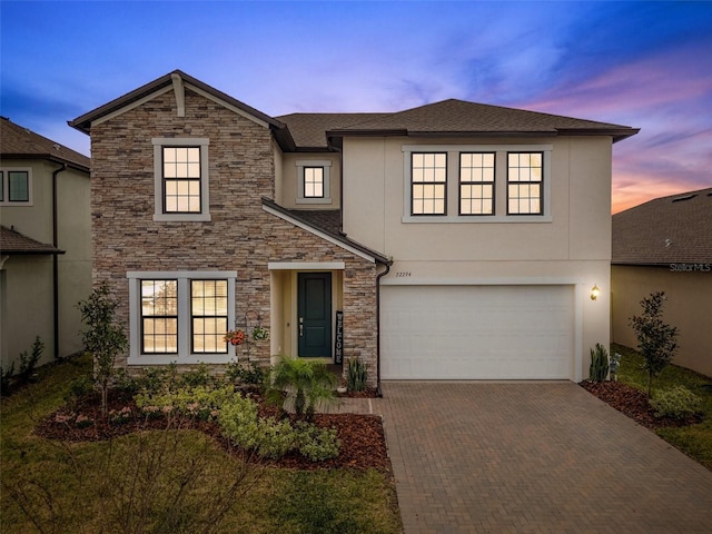 22294 Storybook Cabin Way, Land O Lakes, FL 34637 - view of front of home with stone siding, stucco siding, decorative driveway, and a garage