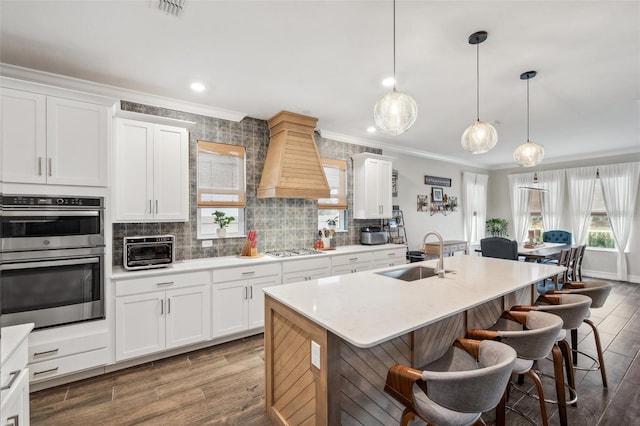 22294 Storybook Cabin Way, Land O Lakes, FL 34637 - kitchen with a sink, stainless steel appliances, crown molding, a kitchen bar, and wood finished floors