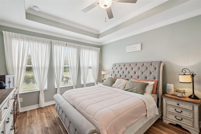 22294 Storybook Cabin Way, Land O Lakes, FL 34637 - bedroom with a tray ceiling, baseboards, ornamental molding, light wood-type flooring, and a ceiling fan