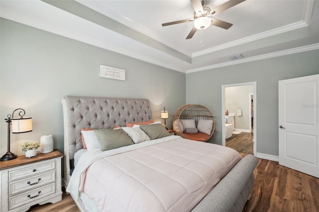 22294 Storybook Cabin Way, Land O Lakes, FL 34637 - bedroom featuring a raised ceiling, wood finished floors, baseboards, crown molding, and ensuite bath