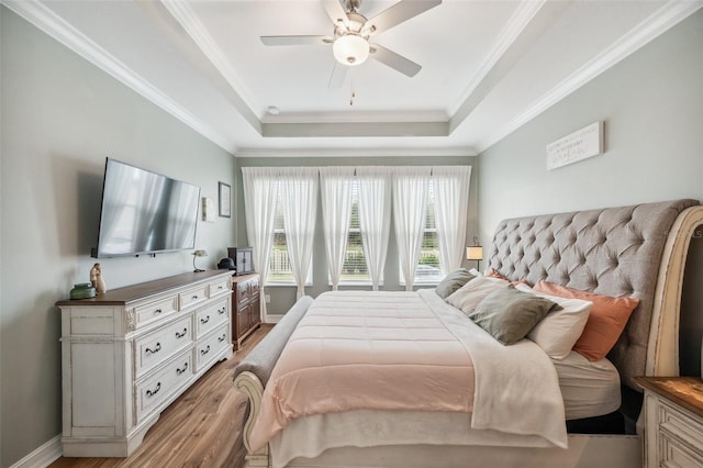 22294 Storybook Cabin Way, Land O Lakes, FL 34637 - bedroom featuring a raised ceiling, light wood-type flooring, ornamental molding, ceiling fan, and baseboards