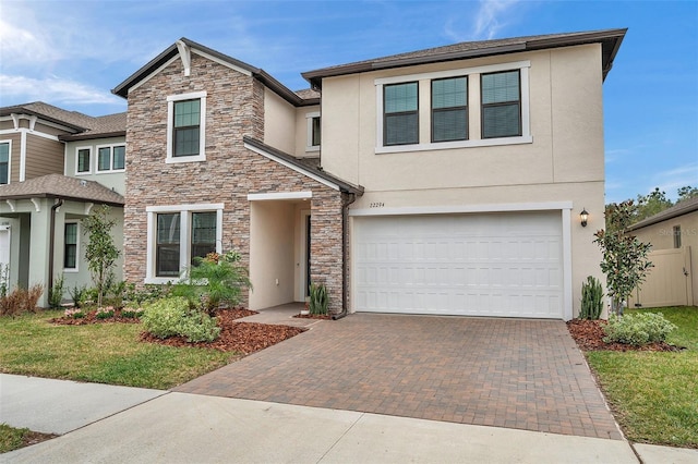 22294 Storybook Cabin Way, Land O Lakes, FL 34637 - view of front facade featuring stone siding, stucco siding, a garage, and decorative driveway