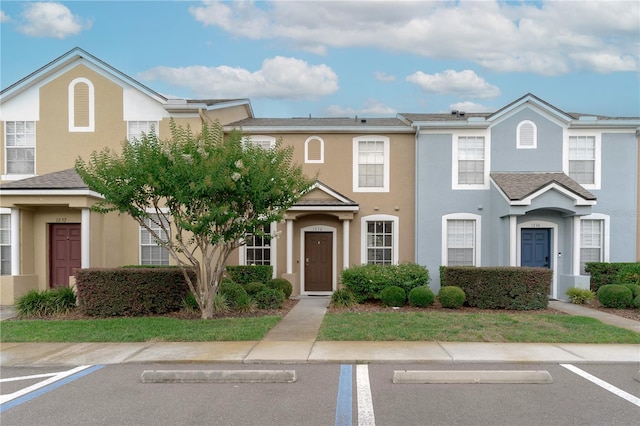 multi unit property featuring uncovered parking and stucco siding